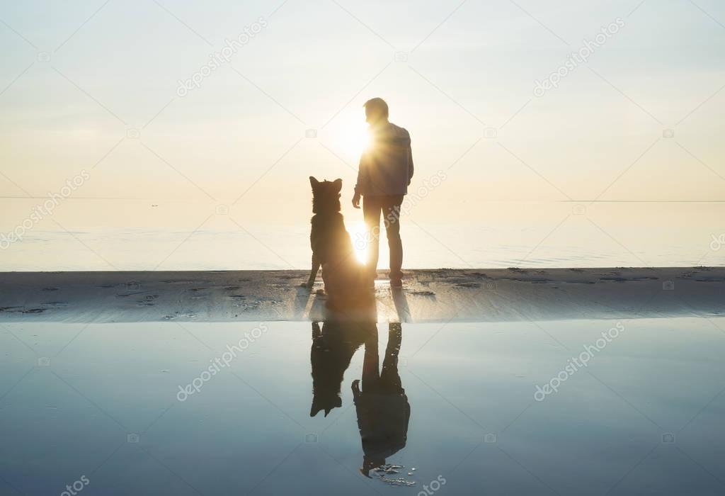 Men with dog friend on the beach. Concept and idea