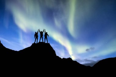 Silhouette of a team on the northern light background. Concept and idea of active life clipart