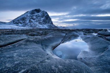 Gün batımı sırasında taşlarla deniz kıyısı. Norveç'te güzel doğal deniz manzarası