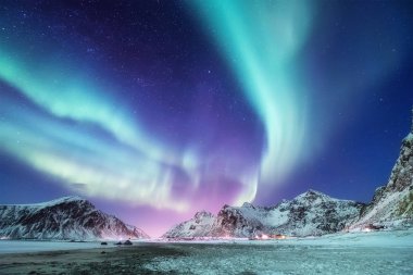 Norveç, Lofoten Adaları 'ndaki Aurora Borealis. Dağların üzerinde yeşil kuzey ışıkları. Aurora ile gece kışı manzarası. Norveç 'te doğal geçmiş