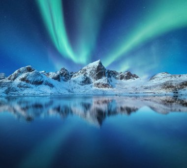 Dağlar ve gökyüzündeki kuzey ışıkları. Gece gökyüzünün yansımaları ve suyun üzerindeki dağlar. Norveç 'te kış manzarası