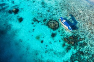 Tekneler su yüzeyinde ve plajlar yukarıdan görünüyor. İHA 'nın gök mavisi arka planı. Havadan gelen yaz deniz manzarası. Seyahat - resim