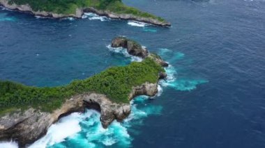 Denizde ve kayalarda hava manzarası. Turkuaz su arka planı. Havadan gelen yaz deniz manzarası. Kelingking plajı, Nusa Penida, Bali, Endonezya. Seyahat videosu