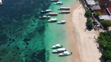 Sahilden ve balıkçı teknelerinden bir arka plan olarak. Üst insansız hava aracının turkuaz su arka planı. Havadan gelen yaz deniz manzarası. Endonezya 'daki Bali Adası. Seyahat videosu