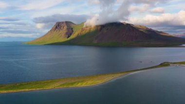 İzlanda. Dağda ve okyanusta hava manzarası. Gündüzleri İzlanda 'da manzara. İzlanda 'da ünlü bir yer. İnsansız hava aracından peyzaj. Seyahat videosu