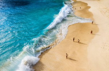Endonezya, Bali sahilindeki insanlar. Tatil ve macera. Kumsal ve büyük dalgalar. Kumsaldaki İHA 'nın üst görüntüsü, masmavi deniz ve insanları rahatlatmak. Seyahat et ve rahatla - görüntü