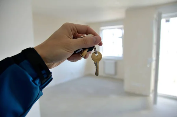 Hand met sleutel in nieuw appartement Stockafbeelding