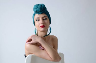 Polonyalı cesur ve kendinden emin bir kadın. Stüdyoda poz veren genç bir kadın. Sarılı türbanlı patates.. 