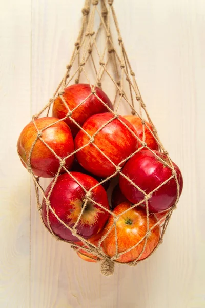 Handmade mesh bag and red apples