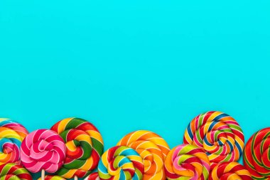 Mavi arka planda yuvarlak renkli lolipoplar