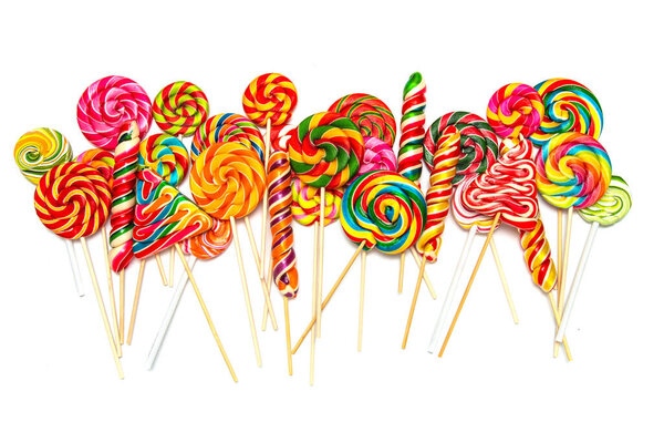 A lot of multi-colored sweet caramel on sticks White background