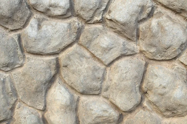 Borda decorativa da fachada do edifício feito de concreto na forma de grandes pedras — Fotografia de Stock