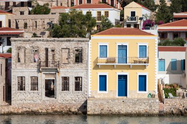 Colorful house and ruined house in Chalki Greece. Contrast between two houses. 