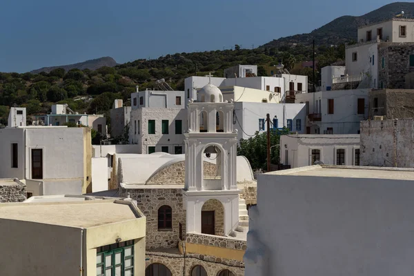 Evlerin önündeki şapel ve yeşil dağ. Mandrakion 'da geleneksel Akdeniz beyaz evleri.