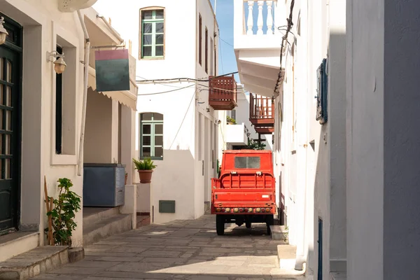 Yunanistan 'ın Mandrakion kentindeki geleneksel Akdeniz caddesi. Mavi pencereli beyaz evler. Fotoğrafta kırmızı araba.. 