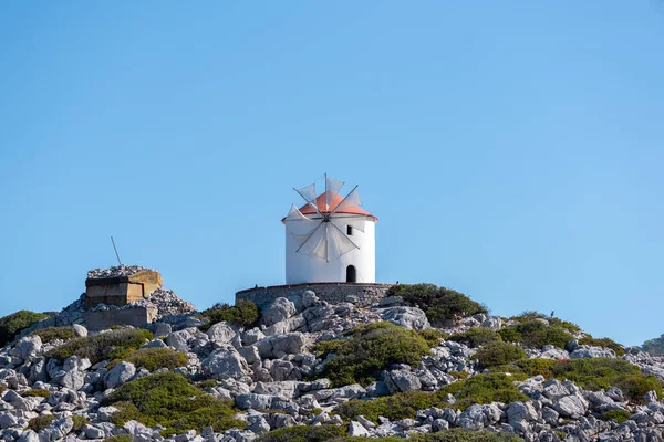 Symi Yunanistan adasındaki yel değirmeni. Yaz güneşli bir günde Rocky Hill 'in tepesindeki güzel yel değirmeni.. 