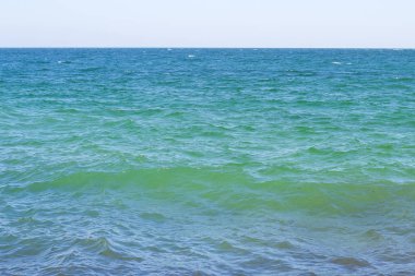 Turkuaz deniz, yaz güneşinin ışınlarıyla aydınlanır.