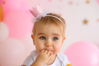 İlk doğum gününde küçük bir kız ve pasta.