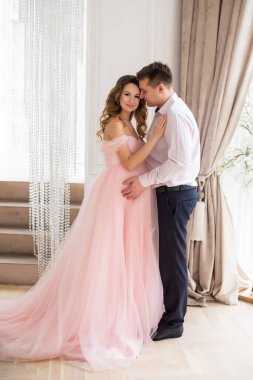 Güzel hamile kadınlar ve pembe elbiseli bir adam.