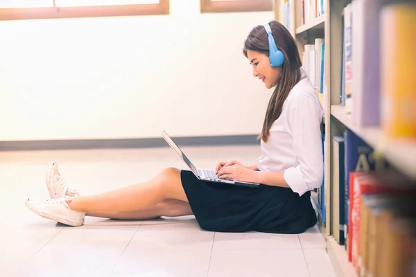 Девушка-подросток с ноутбука в библиотеке — стоковое фото