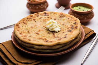 Aloo Paratha / Hint Patatesi üzerine tereyağlı Düz Ekmek. Taze Lassi, turşu ve turşu ile servis edilir. seçici odak