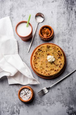 Aloo Paratha / Hint Patatesi üzerine tereyağlı Düz Ekmek. Taze Lassi, turşu ve turşu ile servis edilir. seçici odak