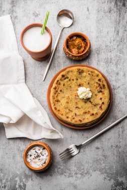 Aloo Paratha / Hint Patatesi üzerine tereyağlı Düz Ekmek. Taze Lassi, turşu ve turşu ile servis edilir. seçici odak