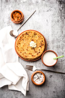 Aloo Paratha / Hint Patatesi üzerine tereyağlı Düz Ekmek. Taze Lassi, turşu ve turşu ile servis edilir. seçici odak