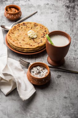 Aloo Paratha / Hint Patatesi üzerine tereyağlı Düz Ekmek. Taze Lassi, turşu ve turşu ile servis edilir. seçici odak