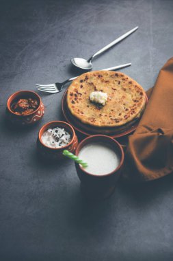 Aloo Paratha / Hint Patatesi üzerine tereyağlı Düz Ekmek. Taze Lassi, turşu ve turşu ile servis edilir. seçici odak