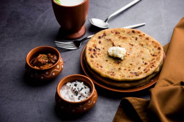Aloo Paratha / Hint Patatesi üzerine tereyağlı Düz Ekmek. Taze Lassi, turşu ve turşu ile servis edilir. seçici odak