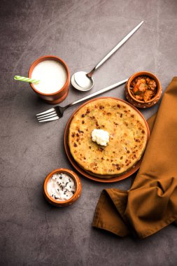 Aloo Paratha / Hint Patatesi üzerine tereyağlı Düz Ekmek. Taze Lassi, turşu ve turşu ile servis edilir. seçici odak