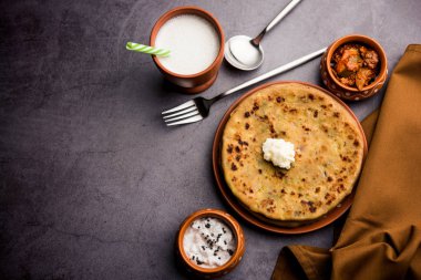 Aloo Paratha / Hint Patatesi üzerine tereyağlı Düz Ekmek. Taze Lassi, turşu ve turşu ile servis edilir. seçici odak