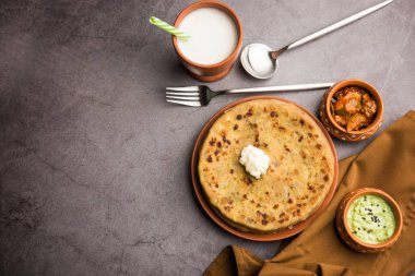 Aloo Paratha / Hint Patatesi üzerine tereyağlı Düz Ekmek. Taze Lassi, turşu ve turşu ile servis edilir. seçici odak