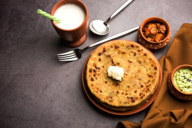 Aloo Paratha / Hint Patatesi üzerine tereyağlı Düz Ekmek. Taze Lassi, turşu ve turşu ile servis edilir. seçici odak