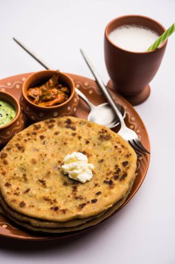 Aloo Paratha / Hint Patatesi üzerine tereyağlı Düz Ekmek. Taze Lassi, turşu ve turşu ile servis edilir. seçici odak