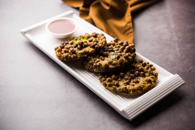 Chana Dal Bhabra / Babra, Hindistan 'ın Bihar / Bhojpur kentinin popüler yemekleri olan domates ketçapıyla servis edildi.