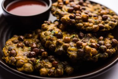 Chana Dal Bhabra / Babra, Hindistan 'ın Bihar / Bhojpur kentinin popüler yemekleri olan domates ketçapıyla servis edildi.