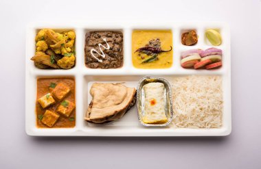 Hint vejetaryen yemek tepsisi ya da içinde paneer, dal makhani / parka, aloo-gobi sabji, chapati ve pilav ve Bengali tatlısı ve salata olan parsel yemek tepsisi.