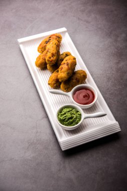 Vejetaryen Poha Roll, yassı pirinç, domates ketçapı ve yeşil turşuyla servis edilir.