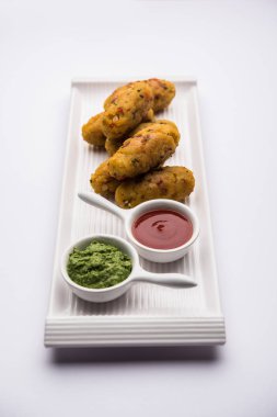 Vejetaryen Poha Roll, yassı pirinç, domates ketçapı ve yeşil turşuyla servis edilir.