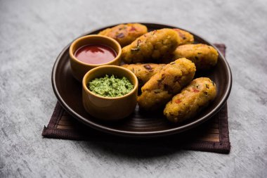 Vejetaryen Poha Pirzolası ya da yassı pirinç köftesi domates ketçap ve yeşil baharatla servis edilir.