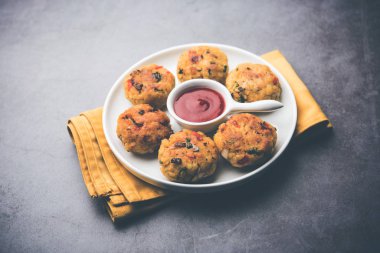 Vejetaryen Poha Pirzolası ya da yassı pirinç köftesi domates ketçap ve yeşil baharatla servis edilir.