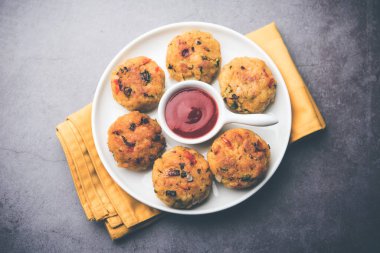 Vejetaryen Poha Pirzolası ya da yassı pirinç köftesi domates ketçap ve yeşil baharatla servis edilir.