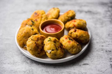 Vejetaryen Poha Pirzolası ya da yassı pirinç köftesi domates ketçap ve yeşil baharatla servis edilir.