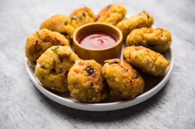 Vejetaryen Poha Pirzolası ya da yassı pirinç köftesi domates ketçap ve yeşil baharatla servis edilir.