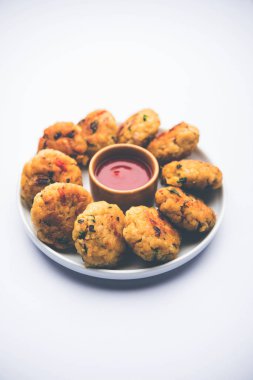 Vejetaryen Poha Pirzolası ya da yassı pirinç köftesi domates ketçap ve yeşil baharatla servis edilir.