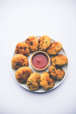 Vejetaryen Poha Pirzolası ya da yassı pirinç köftesi domates ketçap ve yeşil baharatla servis edilir.