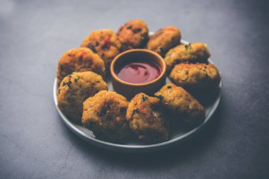 Vejetaryen Poha Pirzolası ya da yassı pirinç köftesi domates ketçap ve yeşil baharatla servis edilir.