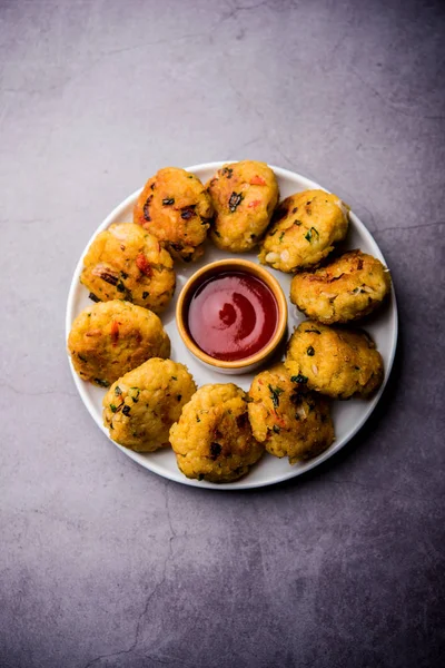 Veg Poha Cutlet or flattened Rice Patties served with tomato ketchup and green chutney